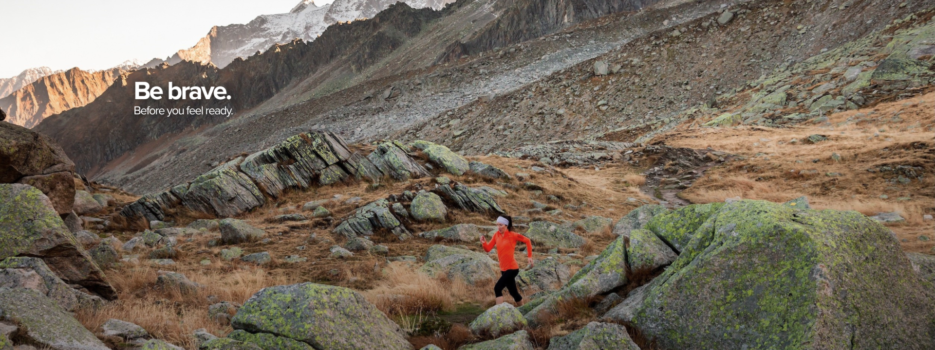 Kaz running in the Chamonix mountains wearing an orange top. Written on the image are the words: Be brave. Before you are ready.